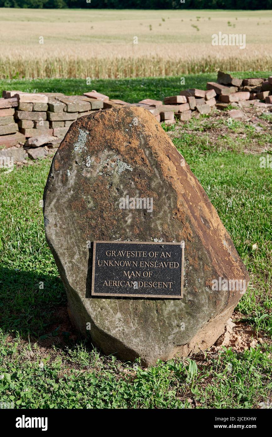 A large stone and metal marker in a Maryland, USA graveyard,   designates the grave of an unknown slave of African descent Stock Photo