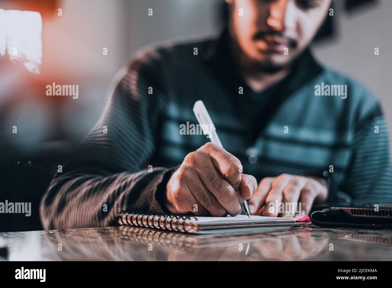 Jotted An inspired man jotting down ideas on a notebook Stock Photo - Alamy