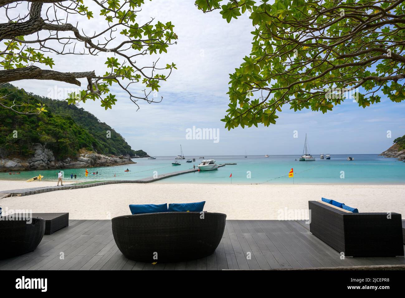 Wooden balcony and living room set by the sea. Relaxing chair set with beach and harbor views in the island of Phuket, Thailand. Peaceful and luxuriou Stock Photo