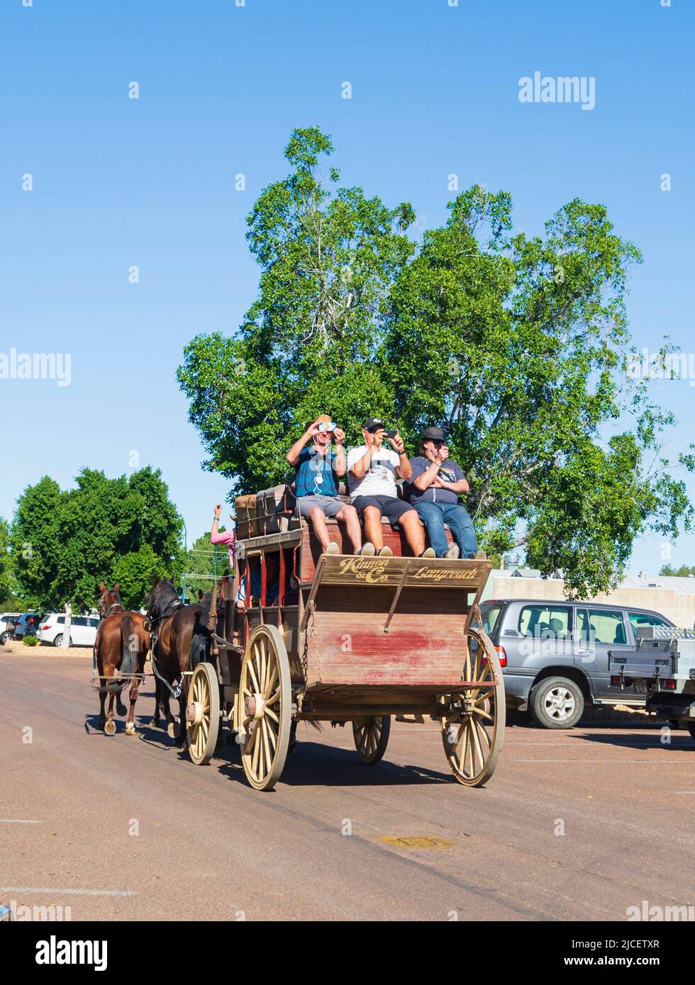 Tourists riding in a Cobb & Co coach pulled by horses, a popular tourist attraction by Kinnon and Co, Longreach, Queensland, QLD, Australia Stock Photo