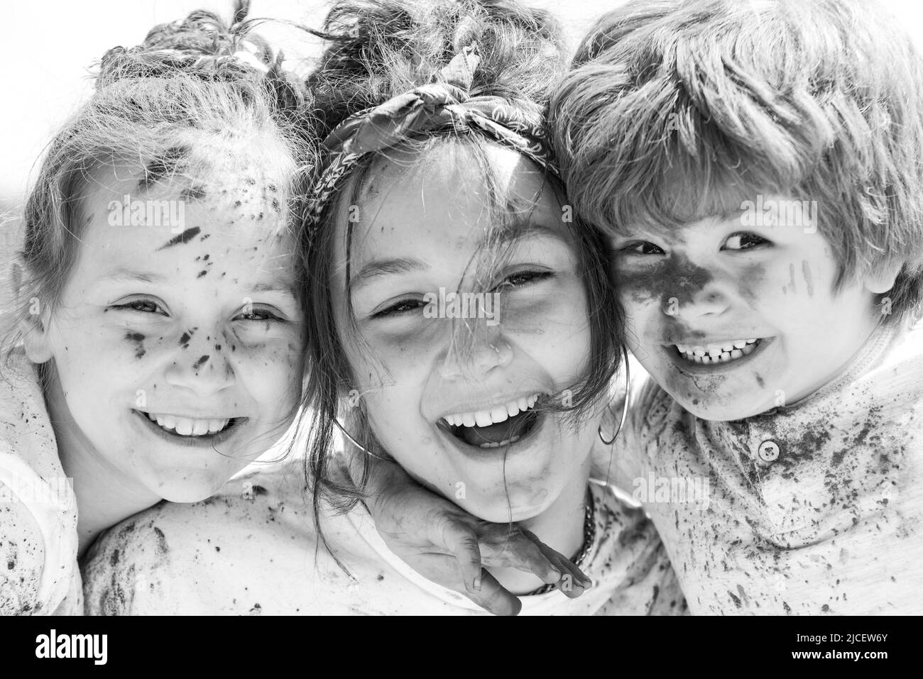Close up portrait of happy excited litttle kids on holi color festival. Cute children with colorful paint powder on faces. Stock Photo