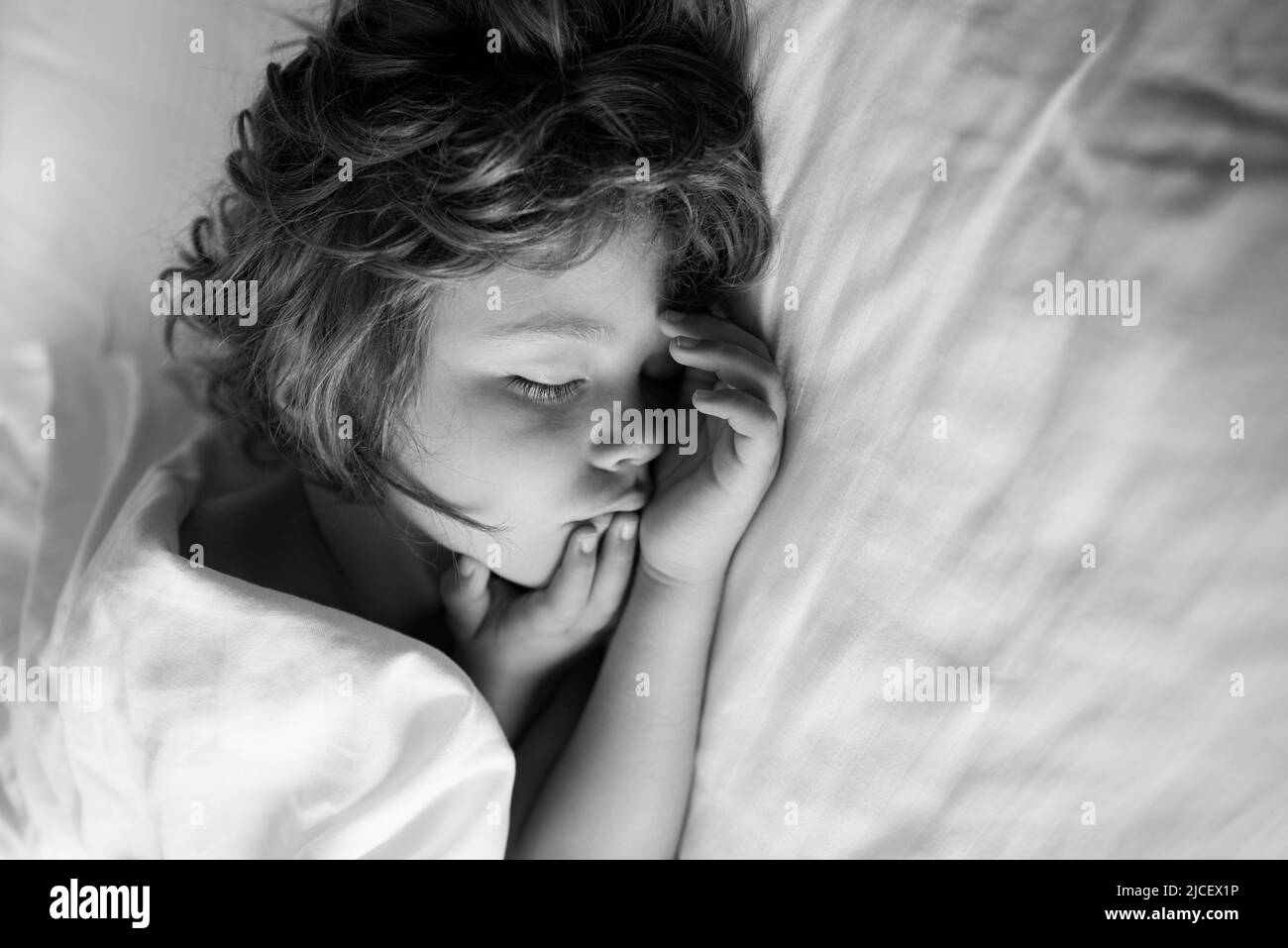Cute kids sleep on white bed. Kid in bedroom sleeping on bed with white