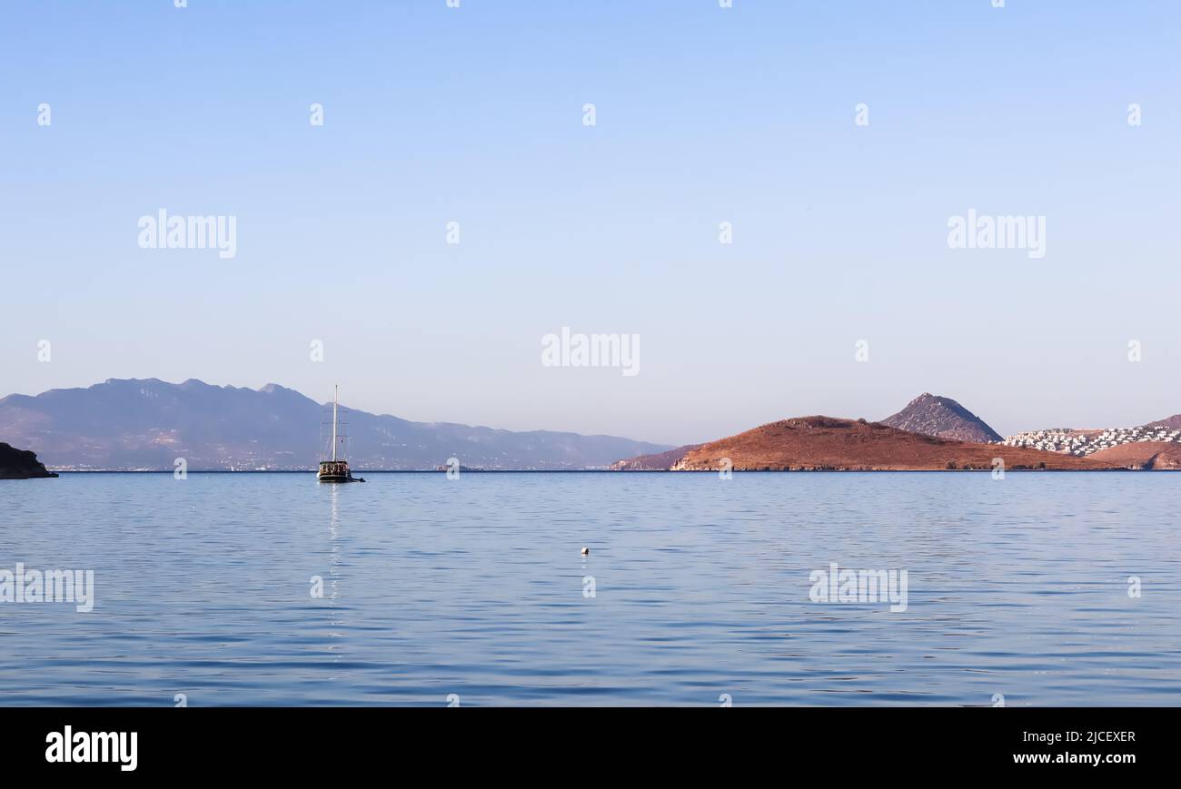 Blue sea, boat, islands and mountains. Calm seascape and coastal nature. Vacation concept Stock Photo