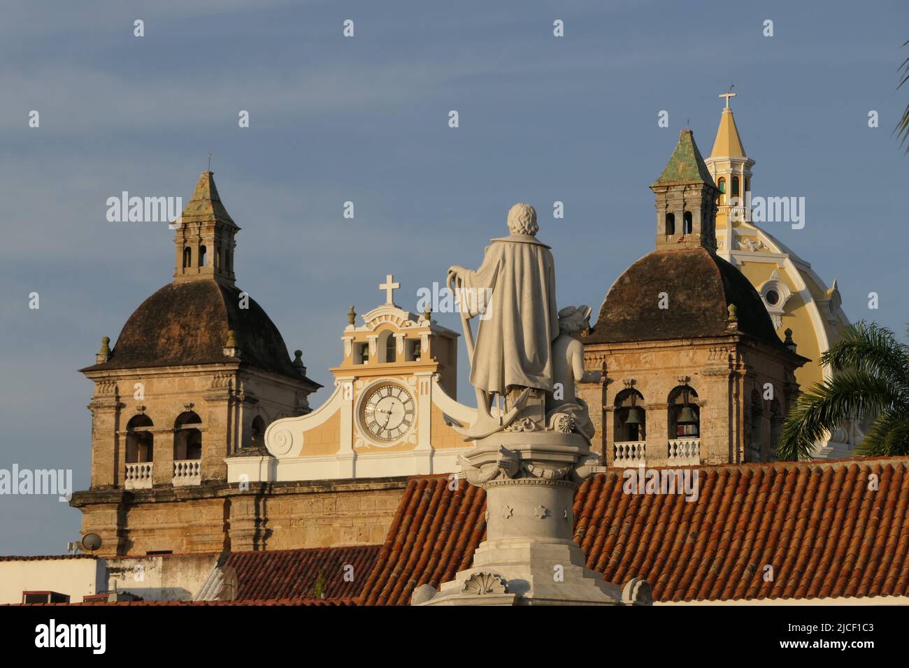 Close-up view over roofs in Cartagena with statue and bell towers of church San Pedro Claver Stock Photo