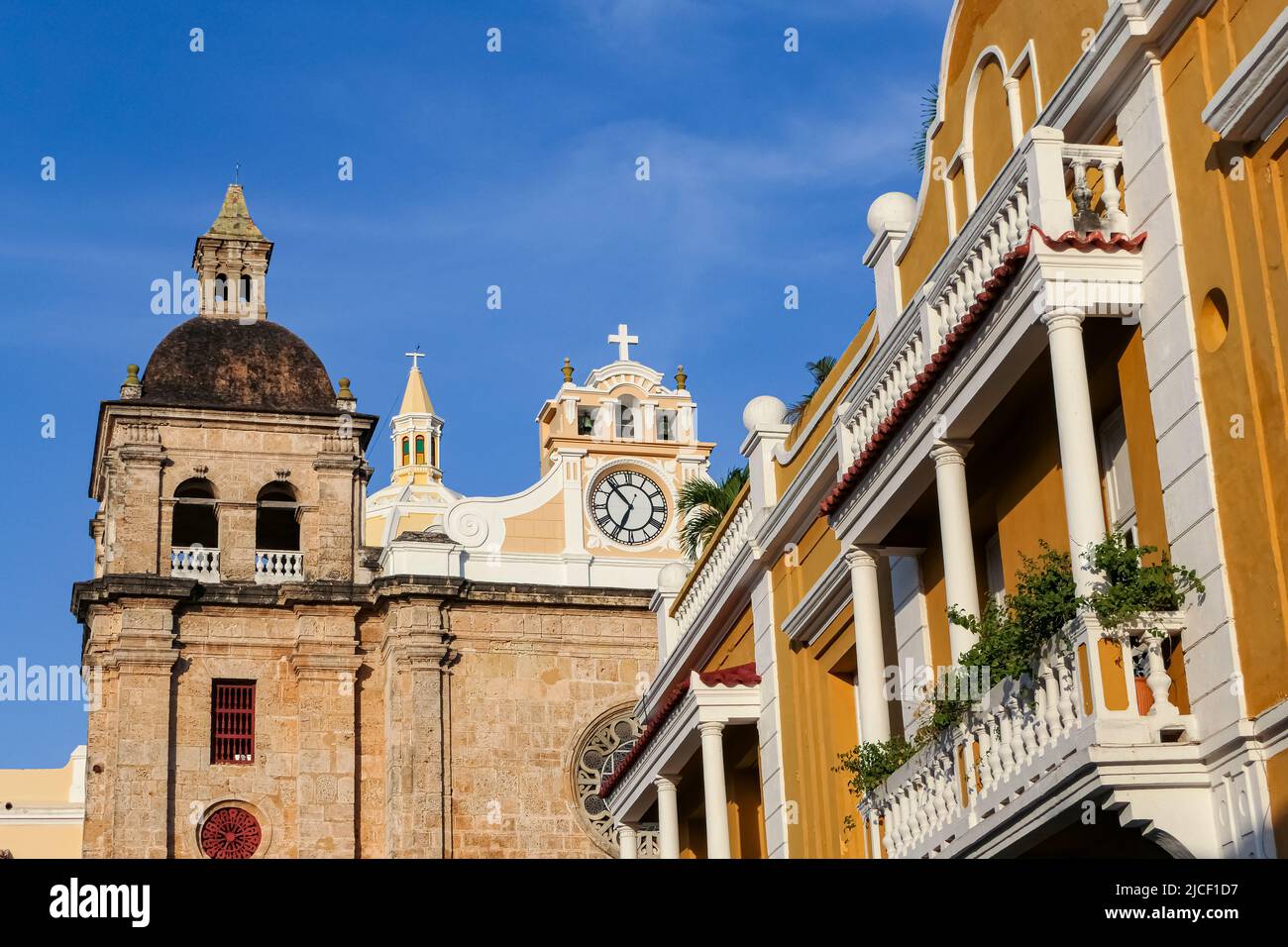 View to ensemble of impressive church San Pedro Claver and traditional colorful houses with blue sky, Cartagena, Colombia, Unesco World Heritage Stock Photo