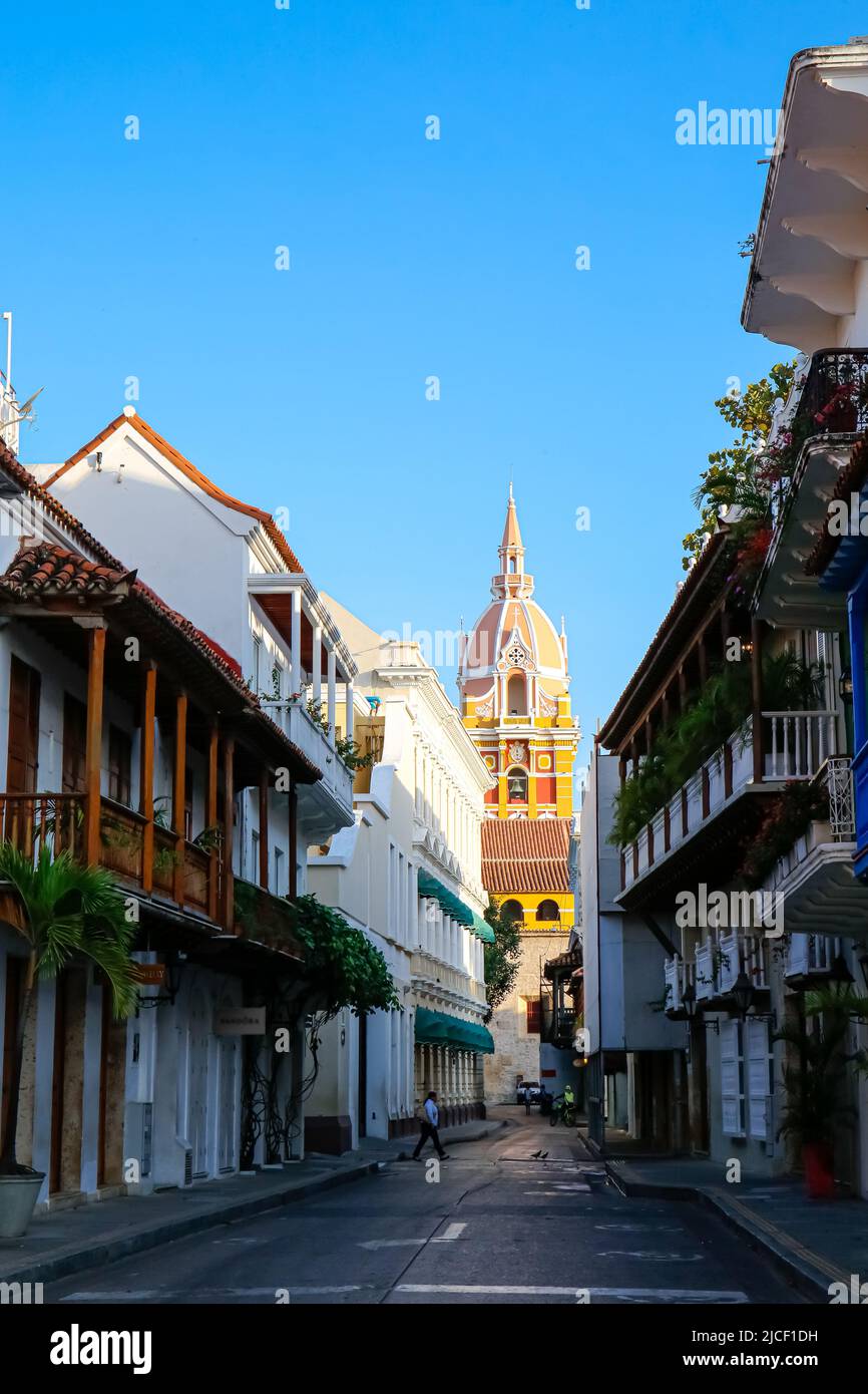 View to the clock tower of Cartagena cathedral with blue sky through a narrow street in shadow, Cartagena, Colombia, Unesco World Heritage Stock Photo