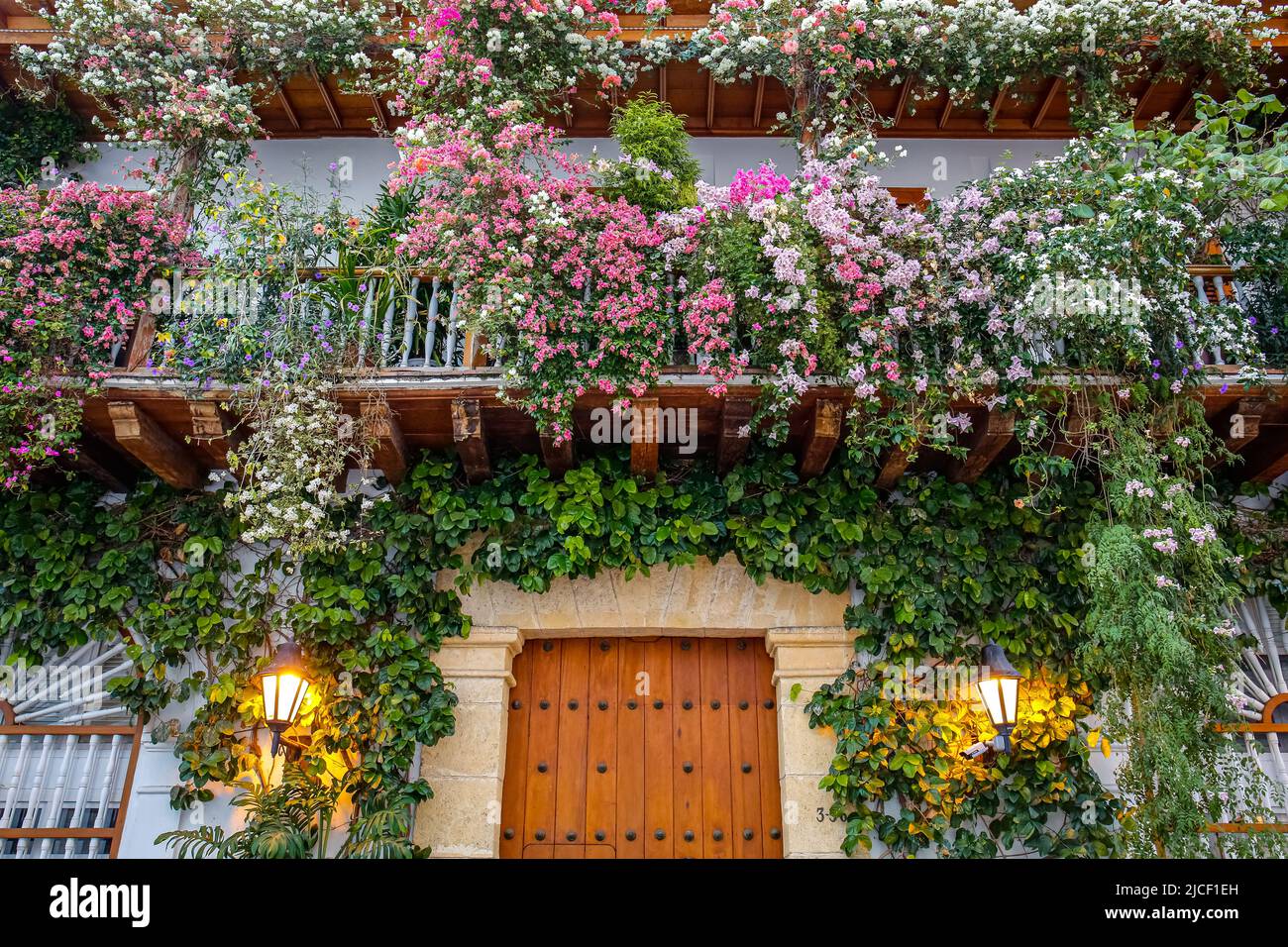 Low angel view to a house entrance and with flowers decorated balconies Stock Photo