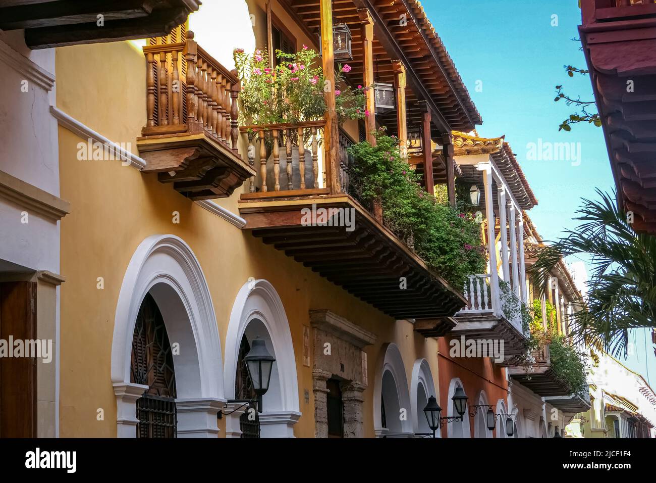 View to artful wooden balconies of historic houses in a narrow street in Cartagena, Colombia Stock Photo