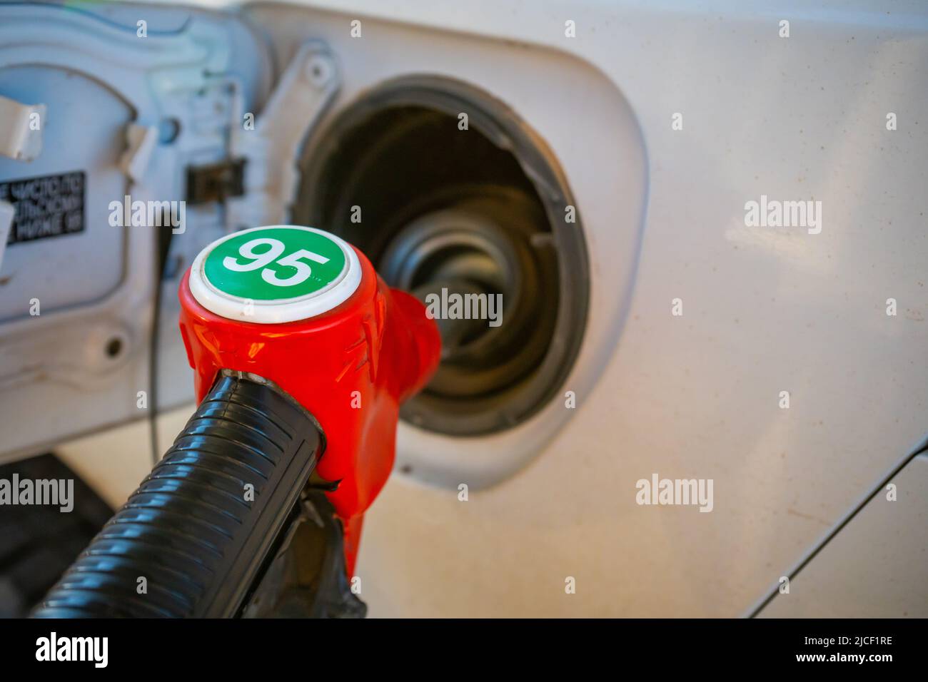 Red nozzle pump Gun petrol from oil pump in the car tank to refueling