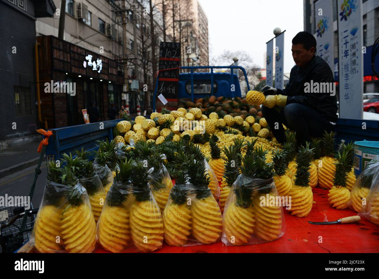 A local man selling peeled pineapples in Nanjing, China. Stock Photo