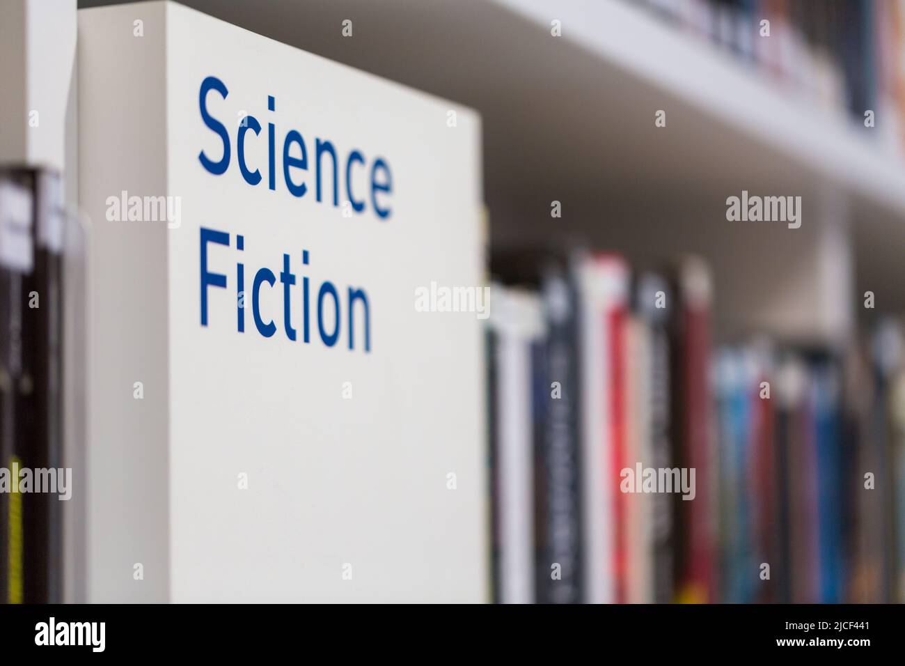 Writing 'Sciene Fiction' in a bookshelf  in a public library. Symbol for futuristic literature and the science fiction genre. Stock Photo