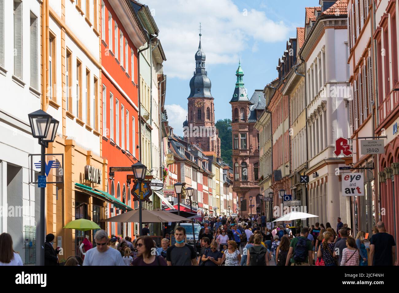 Heidelberg, Germany - Aug 25, 2021: View along the pedestrian zone of Heidelberg. In the background the steeple of the Church of the Holy Spirit. Stock Photo