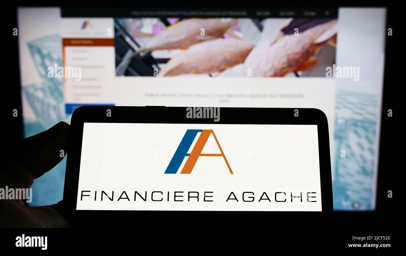 Person holding cellphone with logo of luxury goods company Financiere ...