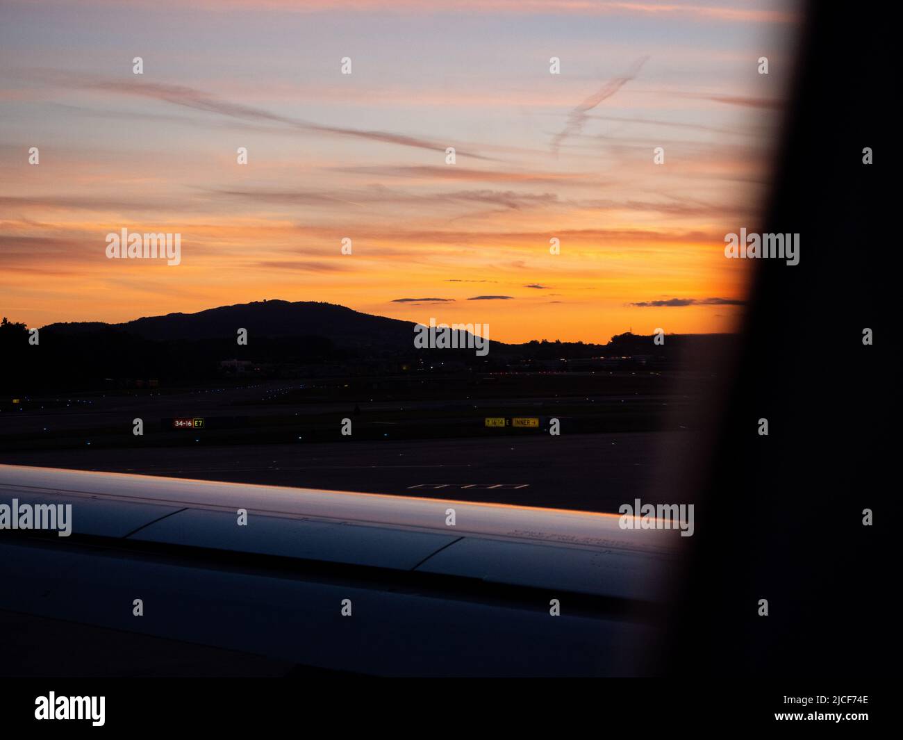 Sunset from A320 at Kloten with airplane wing in foreground. Stock Photo