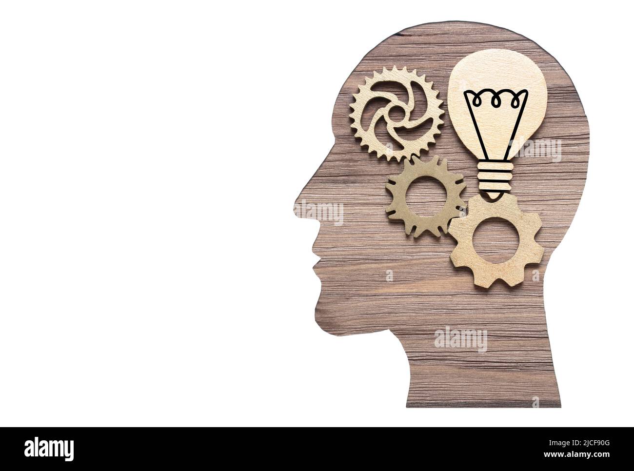 Lightbulb symbol and cogwheels inside a male head paper cut-out on a wooden  background. Creative research and study concept Stock Photo - Alamy