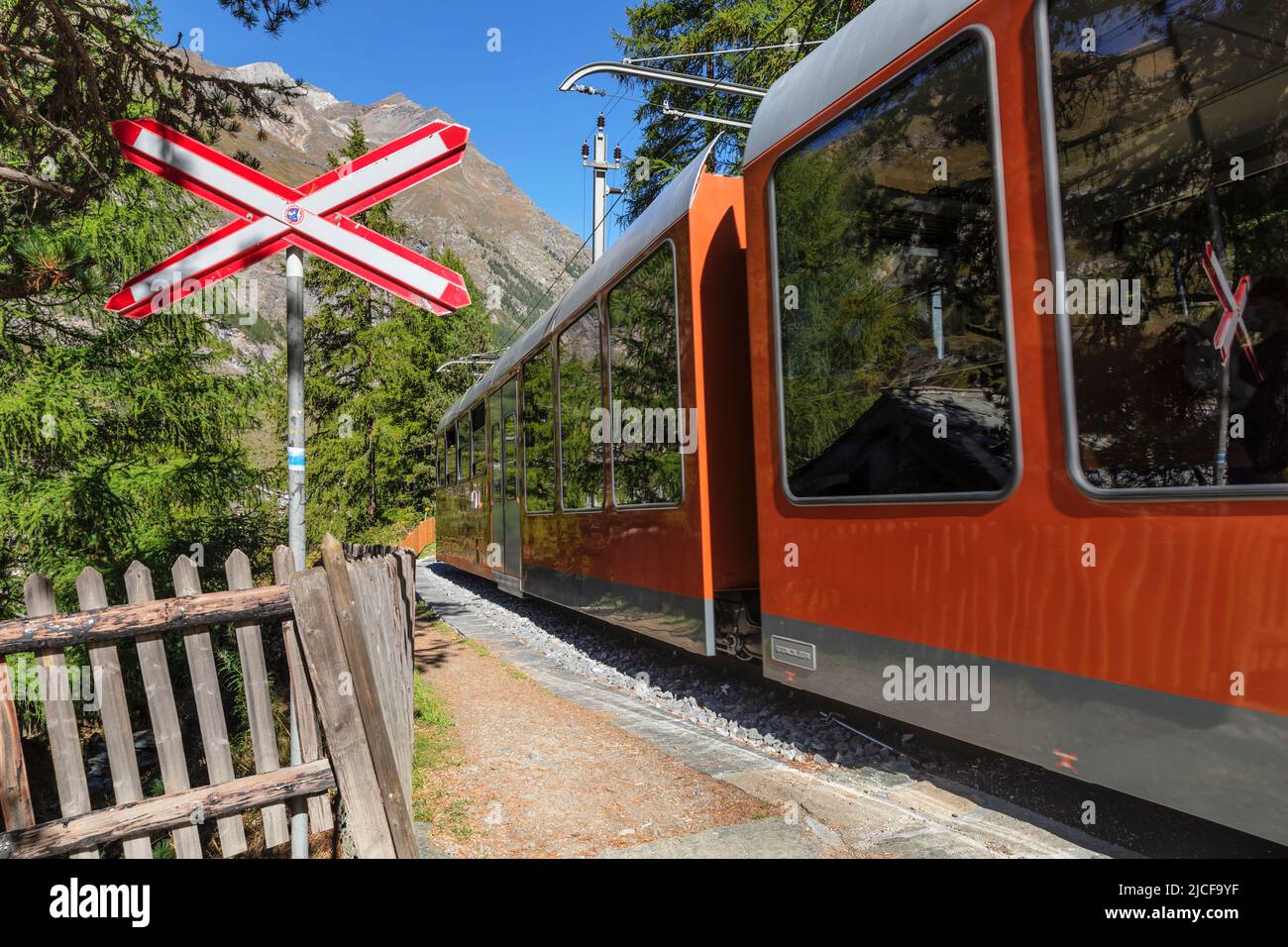 Gornergratbahn cog railroad at a level crossing in Zermatt, Valais, Switzerland Stock Photo