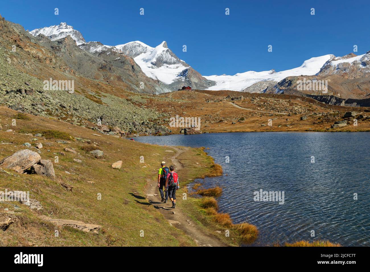 Hiker at Stellisee on the way to Berghaus Fluhalp, Zermatt, Alps, Valais, Switzerland Stock Photo