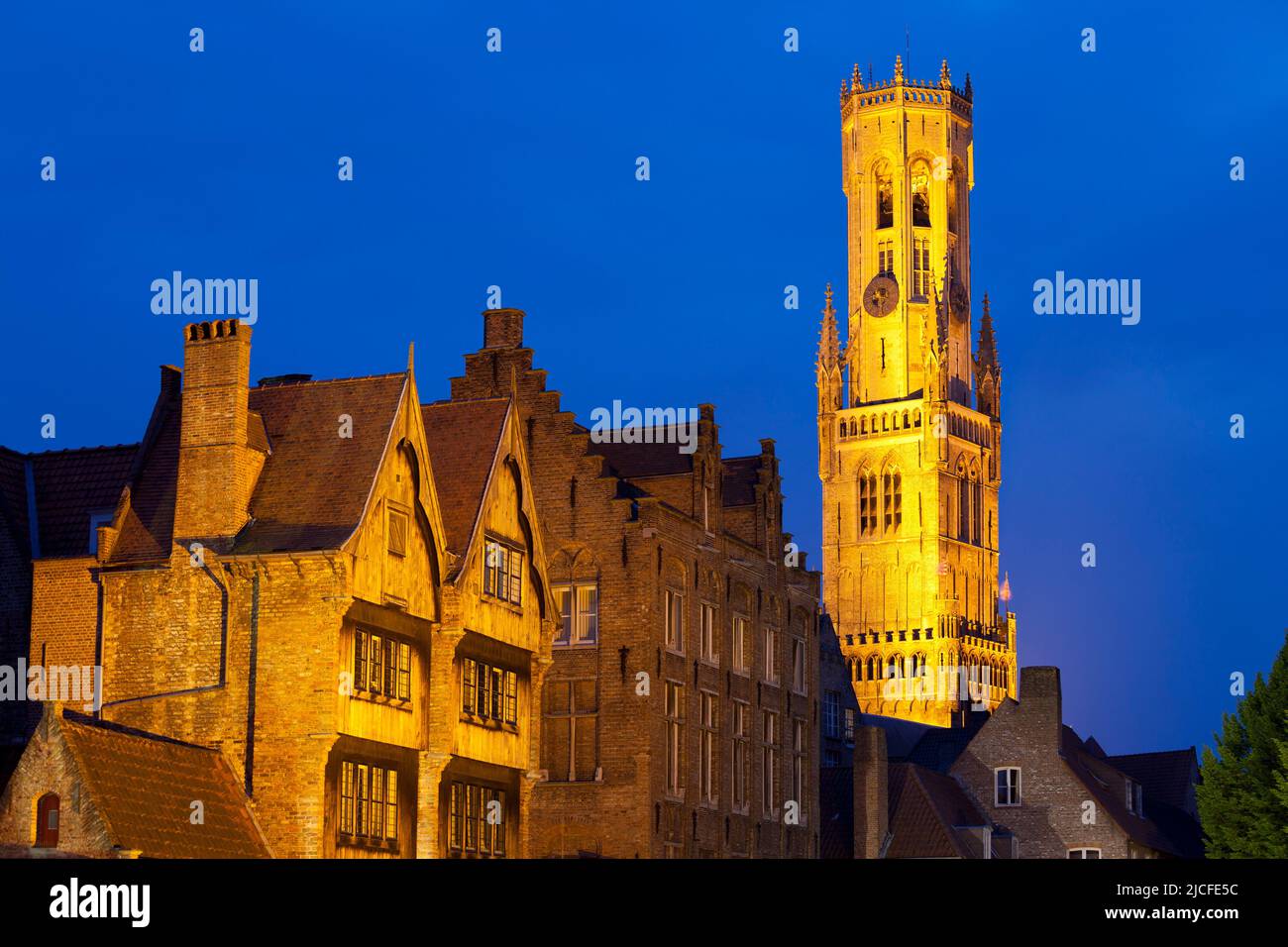 The Bruges Belfry (Belfort Tower) and Buildngs lit up at Night in the Historic Center of Bruges, Belgium Stock Photo