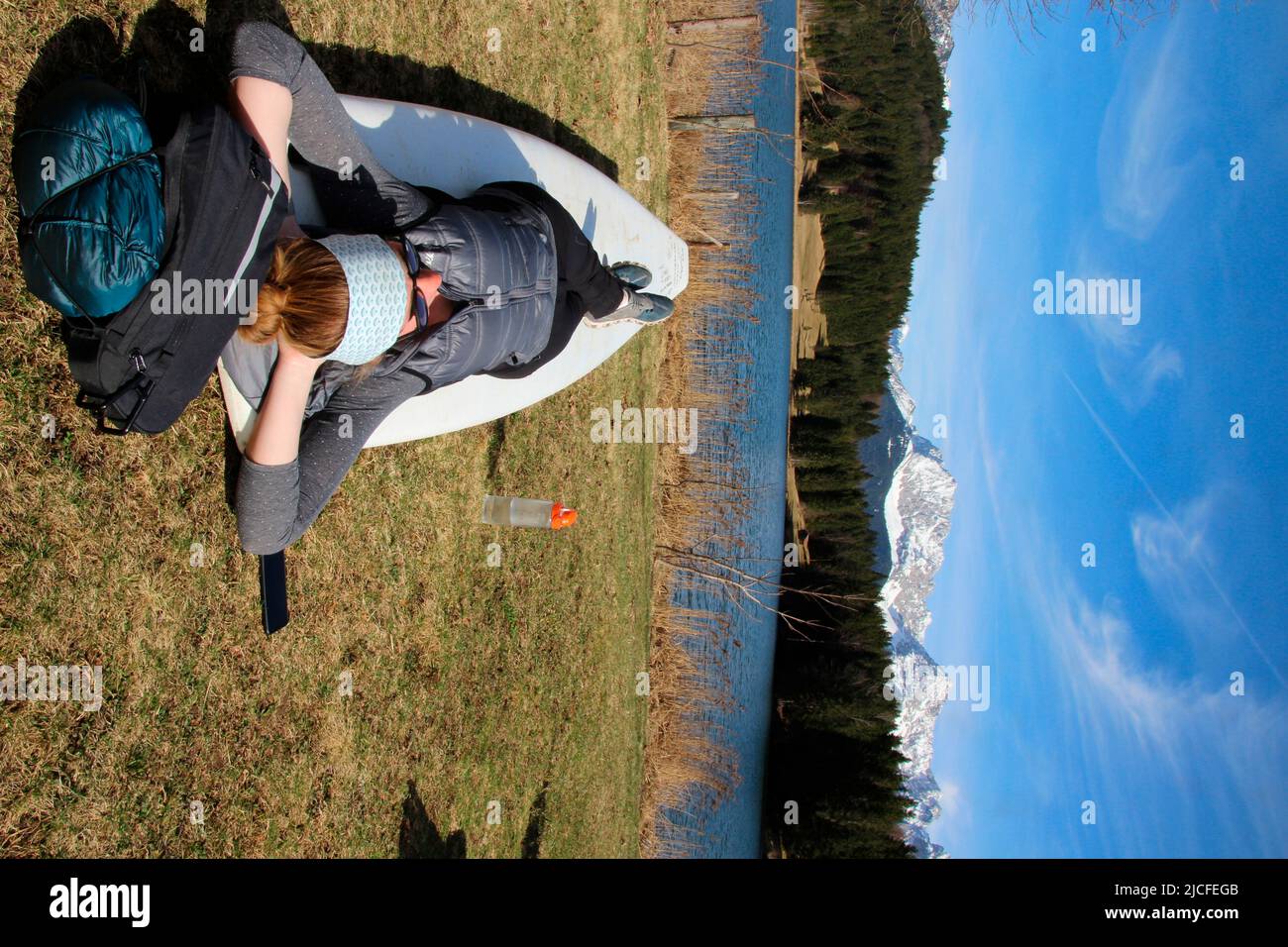 Woman resting on a stand up paddle board, Geroldsee, Germany, Bavaria, Upper Bavaria, Isar Valley, Karwendel Mountains, Stock Photo