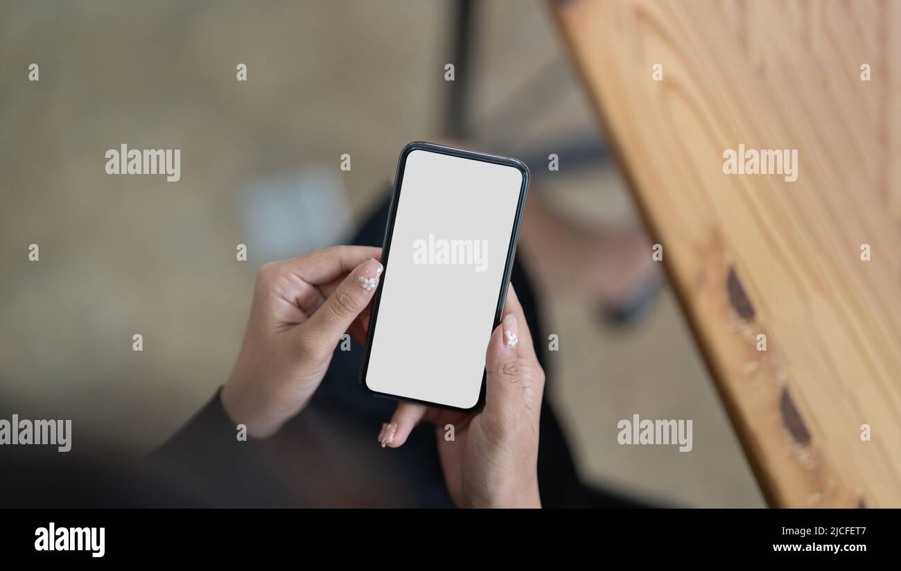 Top view Woman sitting and holding blank screen mock up mobile phone ...