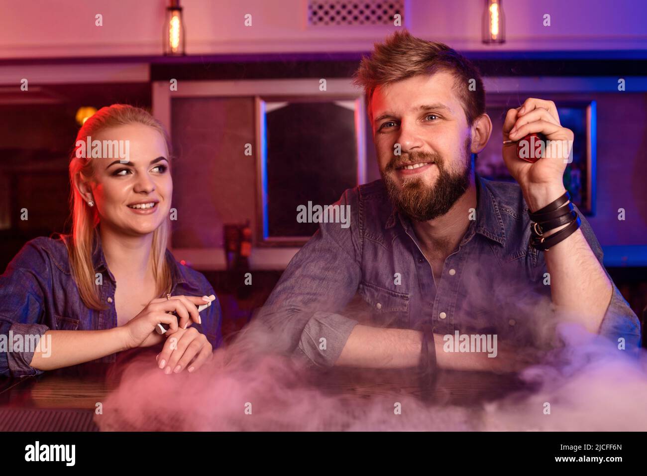 A man and woman smoking electronic cigarette in a vape bar Stock Photo ...