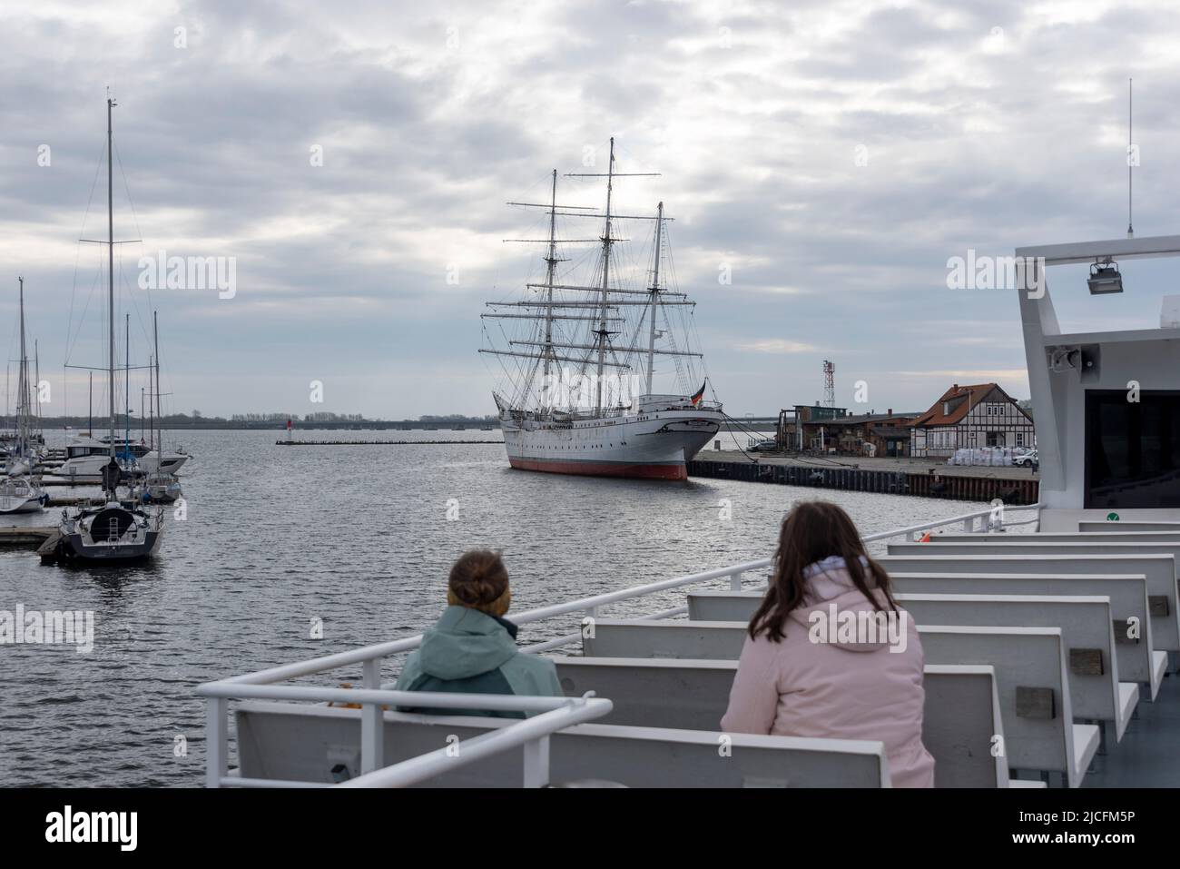 Excursion ship with two tourists, behind them sailing ship Gorch Fock, city harbor Stralsund, Mecklenburg-Western Pomerania, Germany Stock Photo