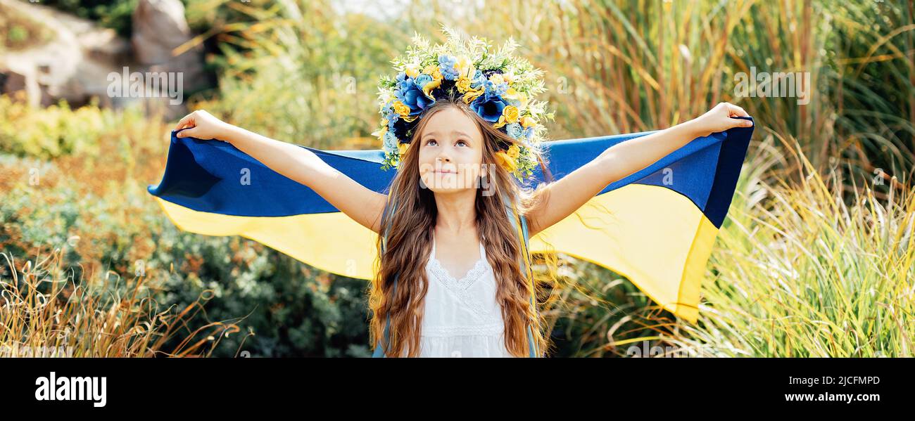 Ukrainian child girl with yellow and blue flag of Ukraine. Family, unity, support. Ukrainians are against war. Constitution day. Ukraines Independence Flag Day. Stock Photo