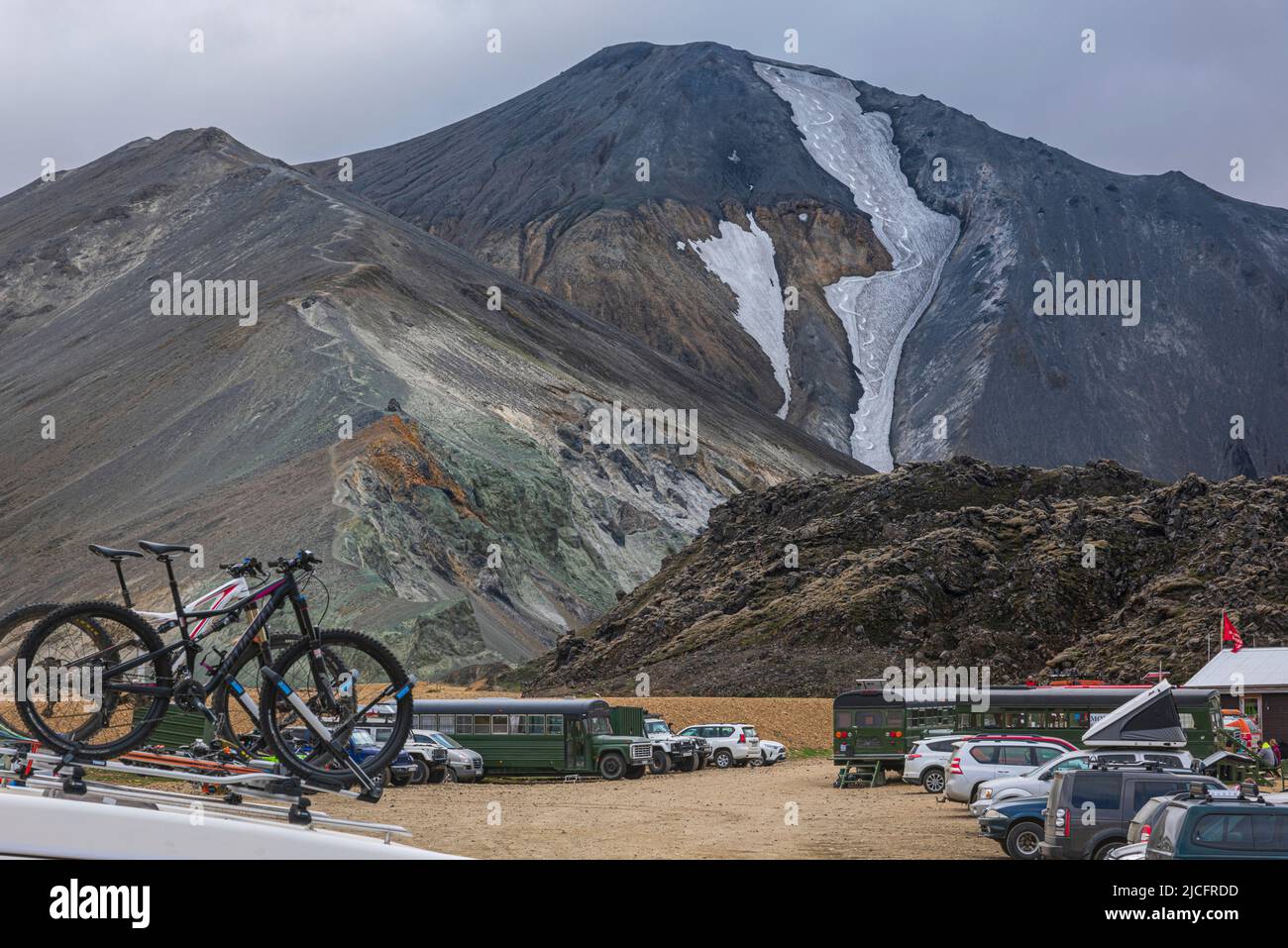 Laugavegur hiking trail is the most famous multi-day trekking tour in Iceland. Landscape shot from the area around Landmannalaugar, starting point of the long-distance hiking trail in the highlands of Iceland. Mountain bikes on a car roof at the parking lot. Stock Photo