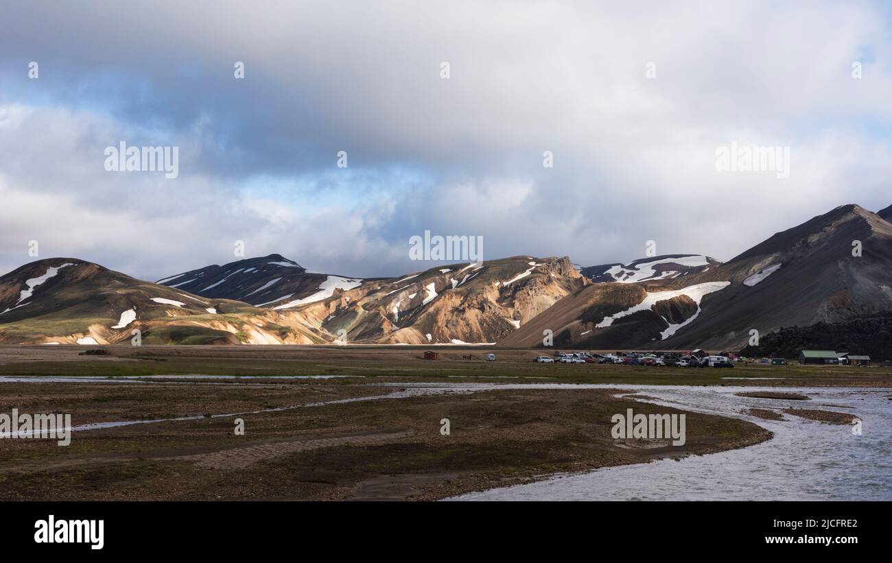 Laugavegur hiking trail is the most famous multi-day trekking tour in Iceland. Landscape shot from the area around Landmannalaugar, starting point of the long-distance hiking trail in the highlands of Iceland. Camping site at the river. Stock Photo
