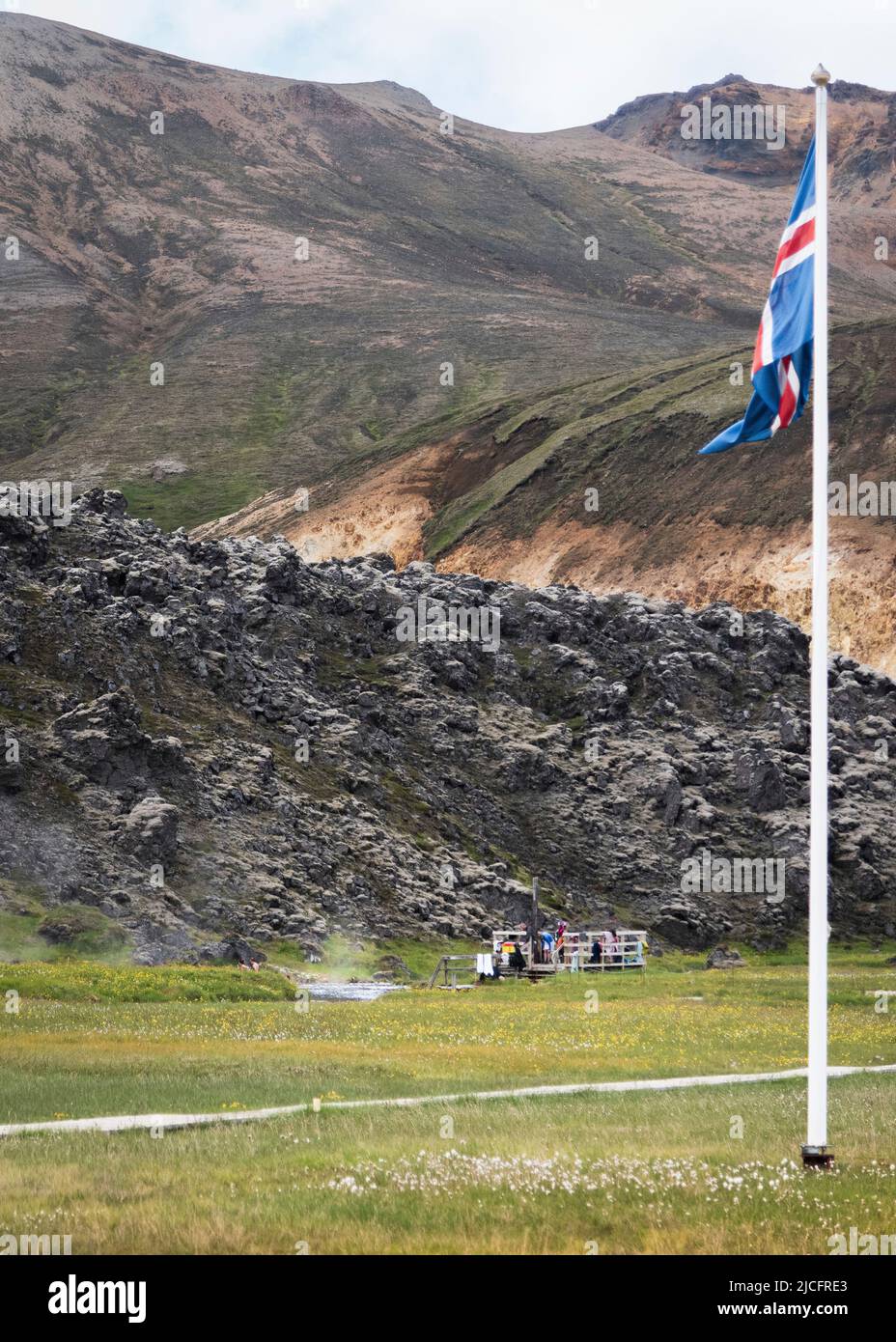 Laugavegur hiking trail is the most famous multi-day trekking tour in Iceland. Landscape shot from the area around Landmannalaugar, starting point of the long-distance hiking trail in the highlands of Iceland. Icelandic flag at the hot pot Stock Photo