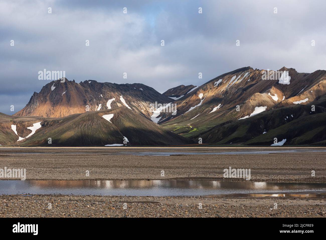 Laugavegur hiking trail is the most famous multi-day trekking tour in Iceland. Landscape shot from the area around Landmannalaugar, starting point of the long-distance hiking trail in the highlands of Iceland near the volcano Hekla. Reflection in the water. Stock Photo