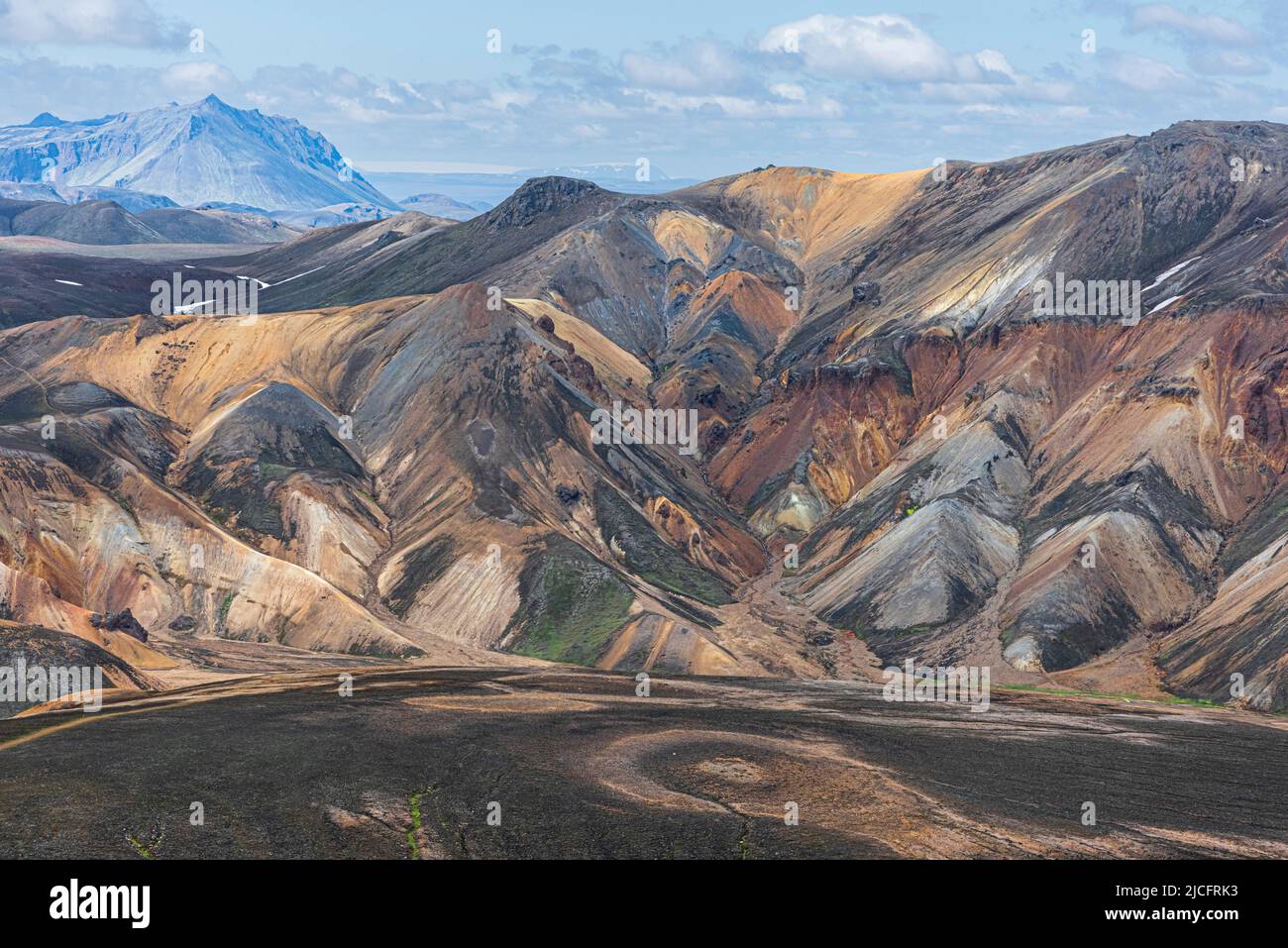 Laugavegur hiking trail is the most famous multi-day trekking tour in Iceland. Landscape shot from the area around Landmannalaugar, starting point of the long-distance hiking trail in the highlands of Iceland. Erosion circle in the foreground. Stock Photo
