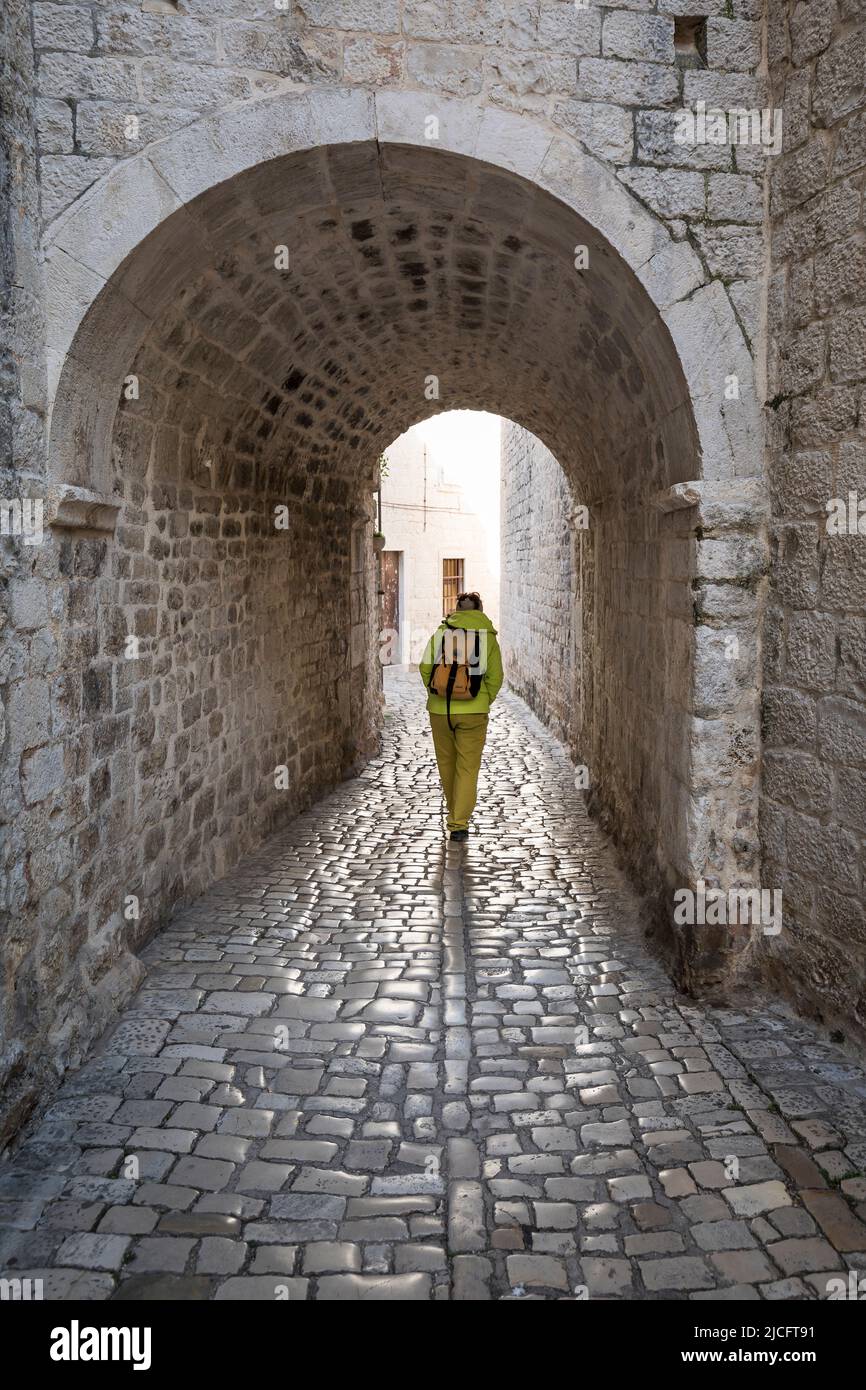 Woman walks through narrow stone hi-res stock photography and images ...