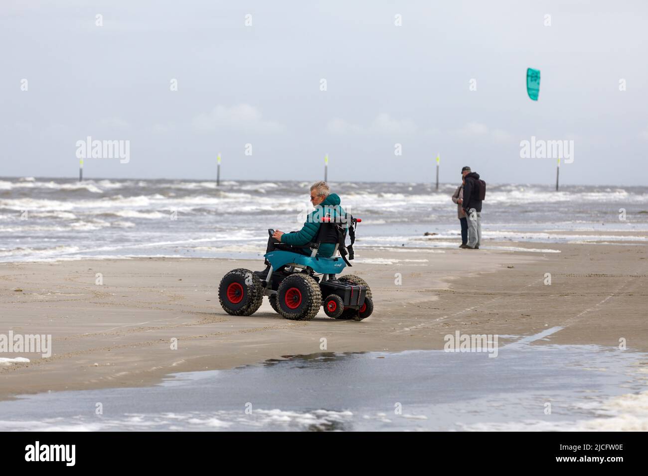 Man with handicap on the beach with a beach wheelchair, Sankt-Peter-Ording, Schleswig-Holstein Stock Photo