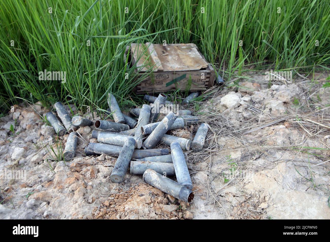 KYIV REGION, UKRAINE - JUNE 4, 2022 - Cartridge cases cover the ground next to an ammunition box on the outskirts of Vovchkiv village where the Ukrain Stock Photo