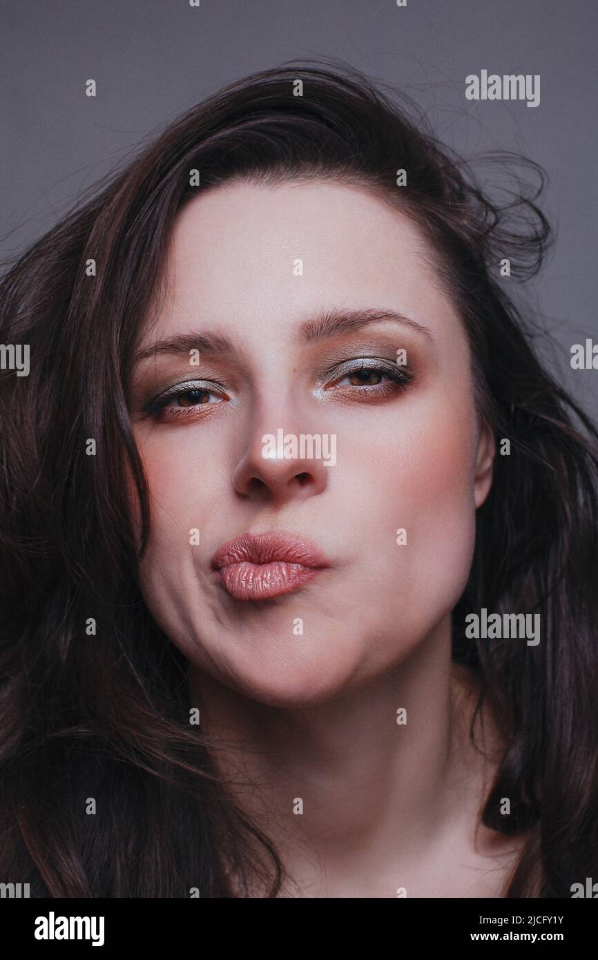 Portrait of a woman wearing nature colored makeup with weird facial expression Stock Photo