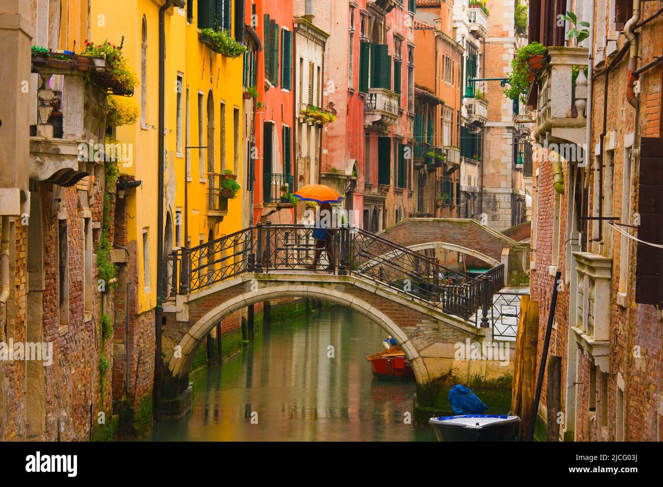 Person with umbrella walking on Bridge over Canal, Venice, Italy Stock Photo