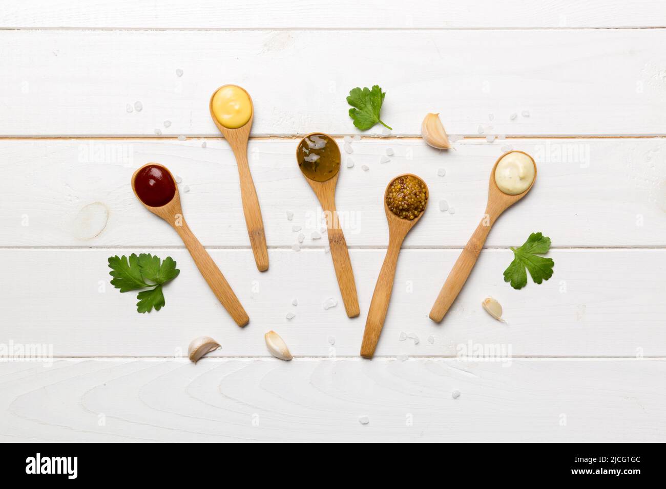 Different sauces in spoons on table background, flat lay top view. Stock Photo