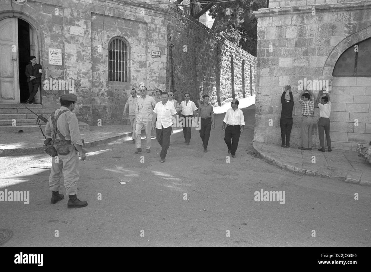 Teddy KOLLEK (withte), Israel, politician, mayor of the city of Jerusalem, walks together with Axel Caesar Cvsssar SPRINGER, Axel C. Springer, through the alleys of the old town, in the foreground on the left is a soldier with a gun, on the right at the wall are civilians with raised arms Hands, black and white photo, landscape format, June 14, 1967. ¬ Stock Photo