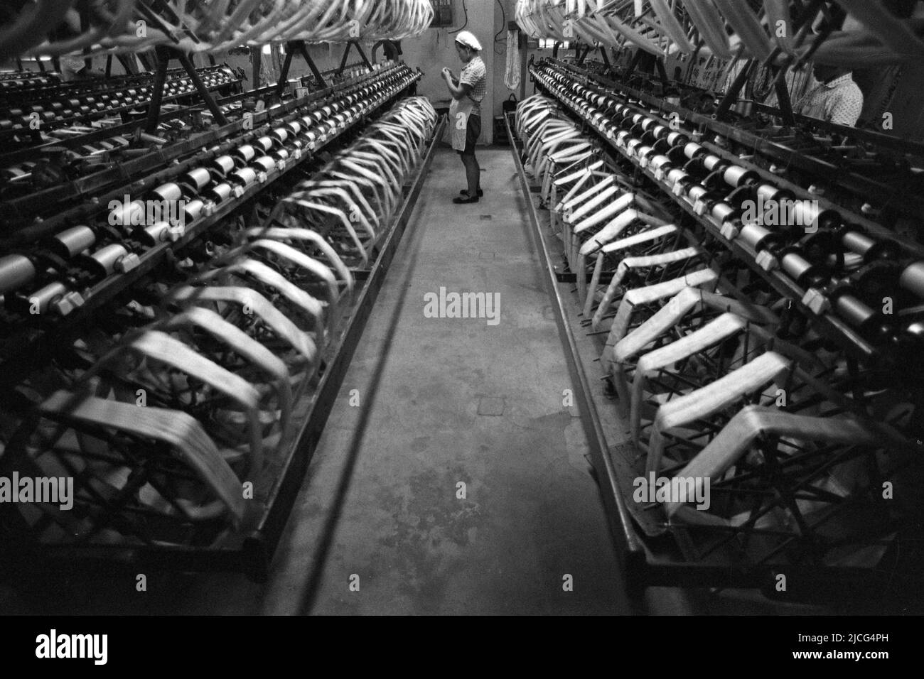 Chinese woman, worker in a textile factory, in the foreground spinning machines, loom, black and white, black and white, black and white, monochrome, SW Monochrome, black and white photo, July 29, 1972 Stock Photo