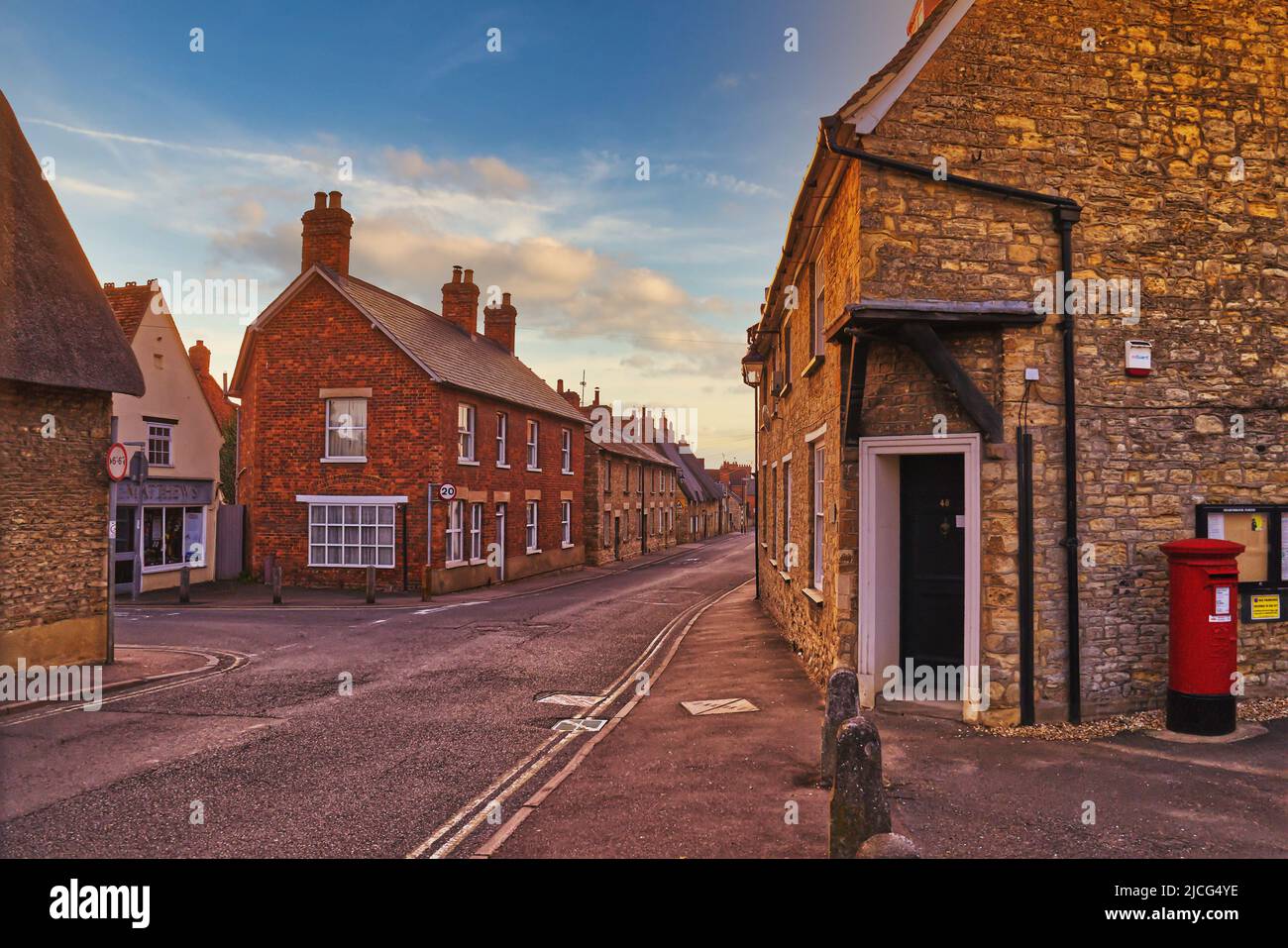 Sharnbrook, Bedfordshire, England, UK - View of cottages and shops along the village high street at sunrise Stock Photo