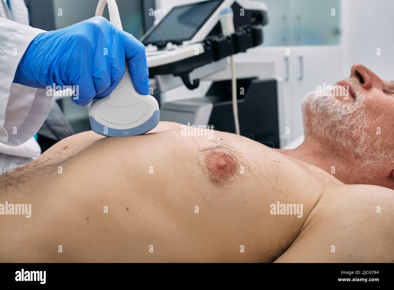 Heart health check-up with ultrasound scan machine. Heart ultrasound exam for elderly man with ultrasound specialist while medical exam Stock Photo
