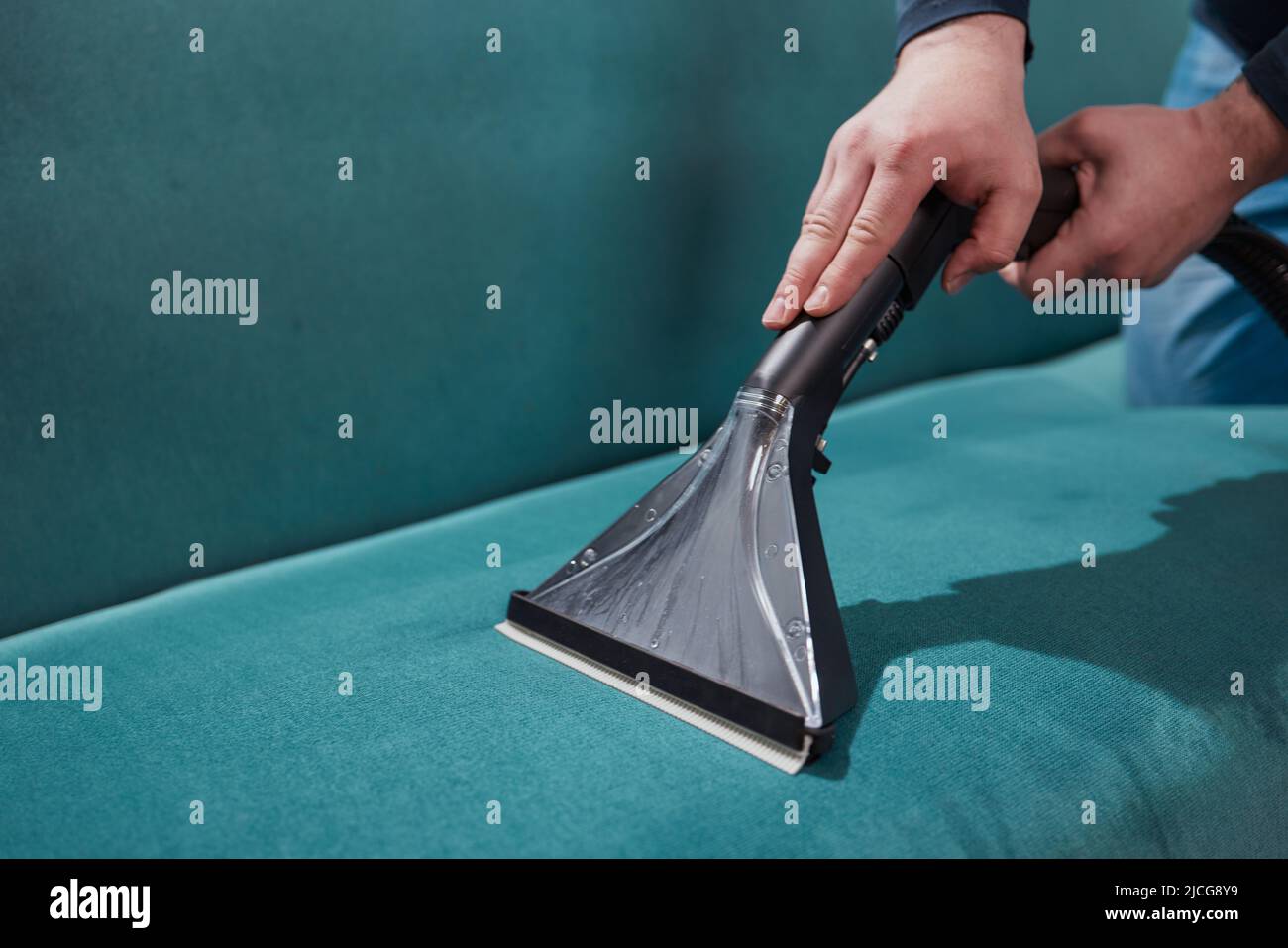 Dry cleaning worker removing dirt from sofa indoors Stock Photo Alamy