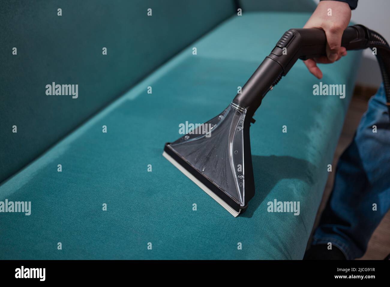 Dry cleaning worker removing dirt from sofa indoors Stock Photo Alamy
