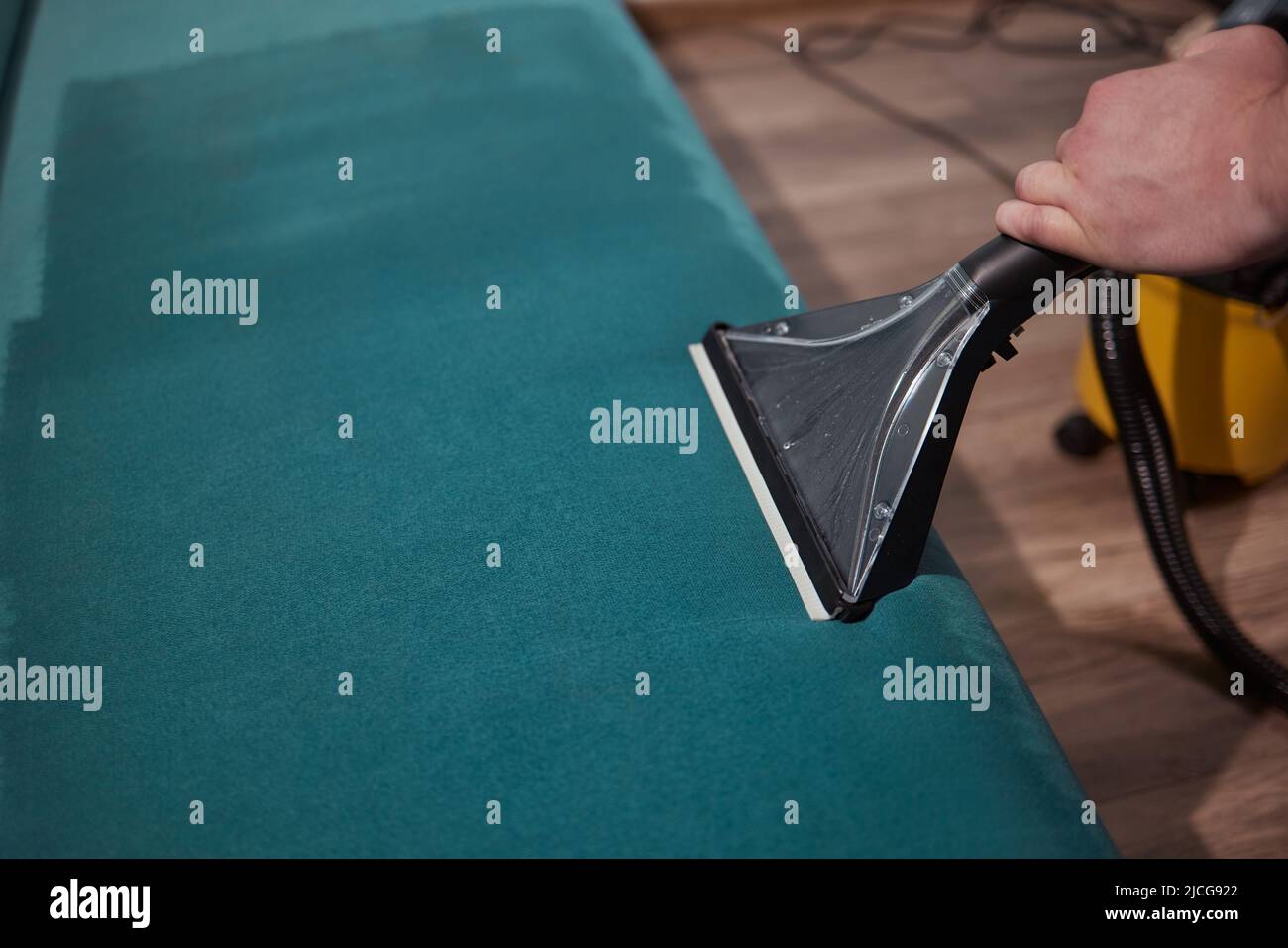 Dry cleaning worker removing dirt from sofa indoors Stock Photo Alamy