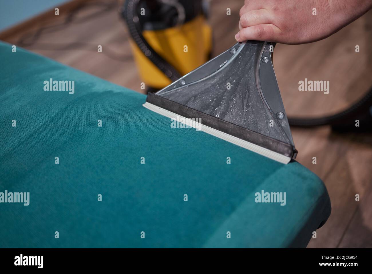 Dry cleaning worker removing dirt from sofa indoors Stock Photo Alamy