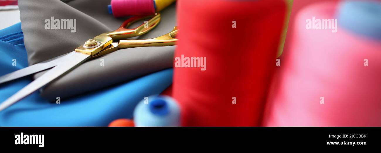 Composition of sewing accessories scissors and threads on fabric Stock Photo