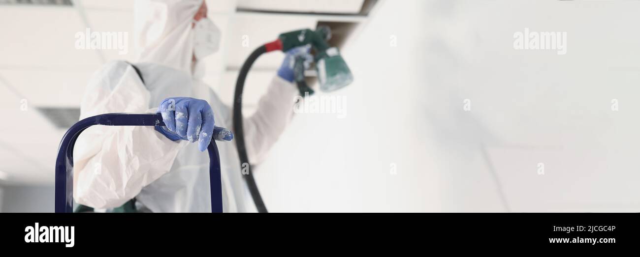 Renovation worker paint wall in uniform using spray gun Stock Photo Alamy