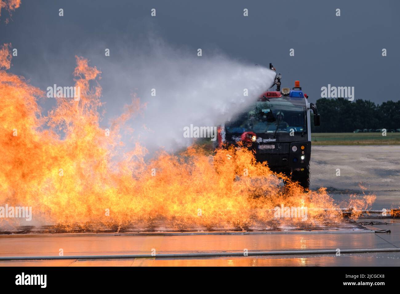 Langenhagen, Germany. 13th June, 2022. Airport firefighters extinguish a wildfire at Hannover Airport during an exercise at the mobile fire simulation facility. The facility is a joint project of Hannover, Stuttgart and Bremen airports and is intended to serve the training and exercise of airport firefighters. Credit: Ole Spata/dpa/Alamy Live News Stock Photo