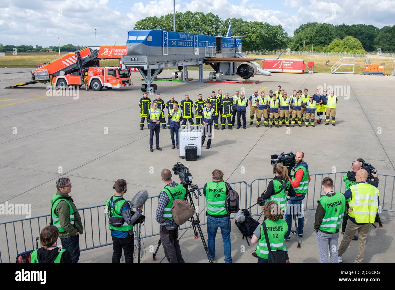Langenhagen, Germany. 13th June, 2022. Media representatives stand on the tarmac at Hannover Airport during the presentation of the mobile fire simulation facility. The facility is a joint project of Hannover, Stuttgart and Bremen airports and is intended to serve the training and exercise of airport firefighters. Credit: Ole Spata/dpa/Alamy Live News Stock Photo